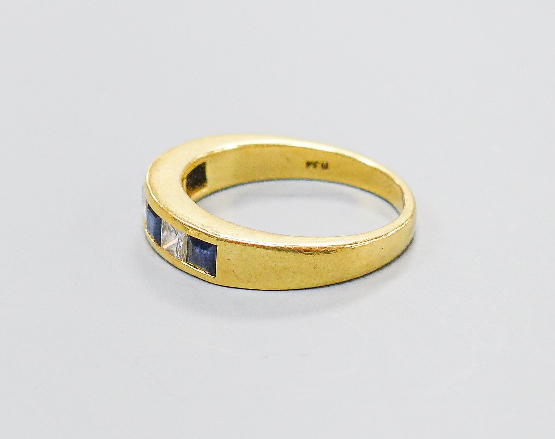 A modern 18ct gold, four stone sapphire and three stone diamond set half hoop ring, size P, gross weight 6.1 grams.